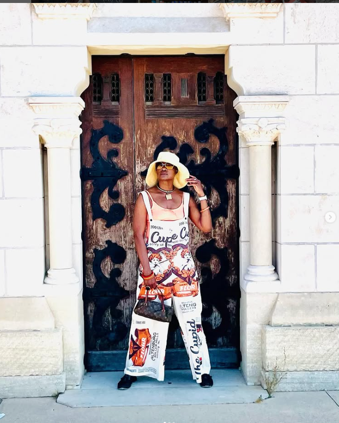 Full‑body campaign look of Dain in front of ornate doors